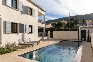 a house with a swimming pool next to a building at Les Cyclistes in Malaucène