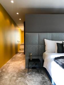 a bedroom with a large bed with a gray headboard at The Crown Penthouse Bahnhofstrasse in Zurich