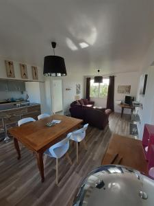 a living room with a table and a couch at Gites Nature & Espace - Le puits des souhaits in Villedieu-les-Poêles