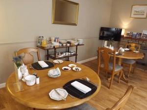 a dining room with a wooden table and chairs at Hazel Bank Bed& Breakfast in Moffat