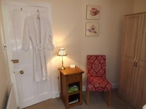 莫法特的住宿－Hazel Bank Bed& Breakfast，卧室配有挂在门上的长袍和椅子