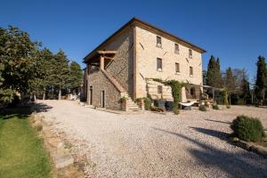 un gran edificio de piedra en un camino de grava en Le Terre di Caprano, en Città di Castello