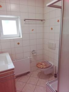 バンシンにあるAppartement Blaue Welleのバスルーム(トイレ、洗面台付)、窓が備わります。