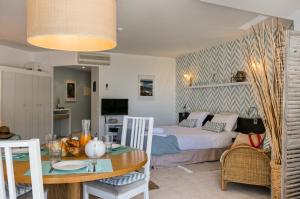 a room with a bed and a table with a dining room at CozyHome - Cabanas in Cabanas de Tavira