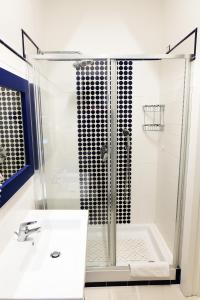 a white bathroom with a shower and a sink at Hotel Baia Di Puolo in Massa Lubrense