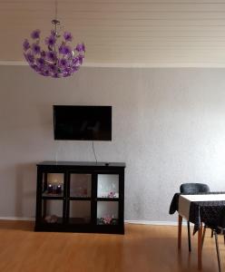 a living room with a tv and a chandelier at Ferienwohnung Hesse in Grimma