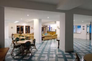 a lobby with tables and chairs and a living room at Hotel Baia Di Puolo in Massa Lubrense