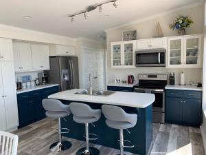 Port Hood的住宿－Colindale Beach Villas，一间设有蓝色橱柜的厨房和一个带凳子的厨房岛