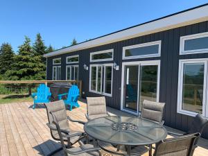 Port HoodColindale Beach Villas的一个带玻璃桌和椅子的屏蔽甲板