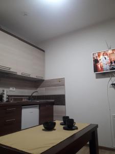 Apartmani Nikola u vili Semeteš في كوباونيك: مطبخ مع طبقين على طاولة مع تلفزيون على الحائط