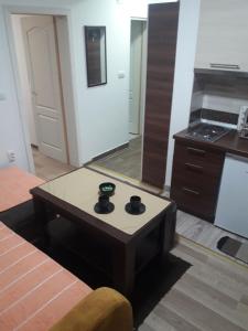 Apartmani Nikola u vili Semeteš في كوباونيك: غرفة معيشة مع طاولة قهوة ومطبخ