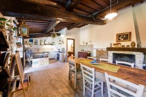 cocina con mesa grande y chimenea en Le Terre di Caprano, en Città di Castello