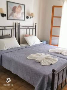 a bedroom with two beds with towels on them at Hill Lofos Hotel in Kassiopi