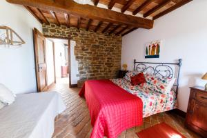1 dormitorio con 1 cama con manta roja en Le Terre di Caprano, en Città di Castello