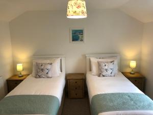 2 camas individuales en una habitación con 2 lámparas en Cleddau View, en Milford Haven