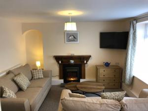 sala de estar con sofá y chimenea en Cleddau View, en Milford Haven