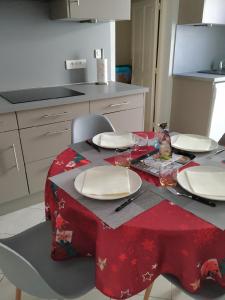 a table with a red table cloth on it in a kitchen at Le Mas du Paulou in Vallon-Pont-dʼArc