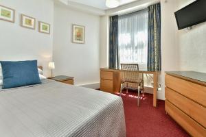 una camera con letto, scrivania e TV di Euro Hotel a Londra