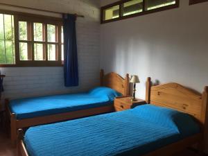 1 dormitorio con 2 camas con sábanas azules y ventana en Casa muy cómoda y acogedora, en Punta del Este
