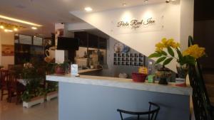 a store with a counter with chairs and flowers at Hostal Perla Real Inn in Guayaquil