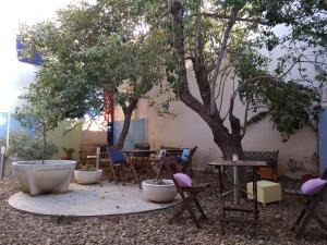 a patio with chairs and a table and a tree at Hospedium Aloque Posada Hotel Rural in Valdepeñas