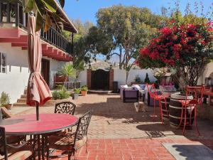 a patio with tables and chairs and a dog sitting in the yard at Hacienda Rancho Santini in Rosarito