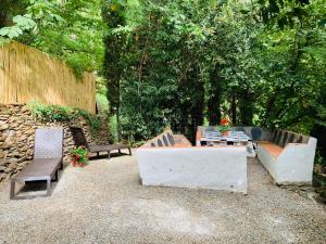 a patio with two benches and a table and chairs at Barranco de la Salud in Laroles