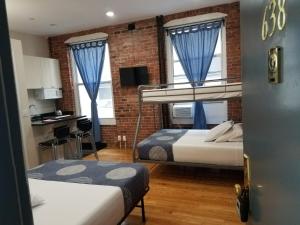 Zimmer mit 2 Etagenbetten und einer Küche in der Unterkunft Studios Midtown Manhattan in New York