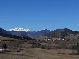 a view of a mountain range with a town in a field at Vue sur L'Ourtizet in Rodome