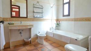 a bathroom with a toilet a sink and a bathtub at La Posada del Conde in Ardales