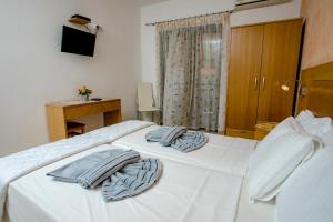 a bedroom with a white bed with towels on it at Maik Apartments in Metamorfosi