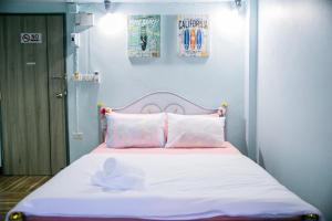 Bangkok Canale Home at Khaosarn في بانكوك: سرير به شراشف ومخدات وردية وبيضاء