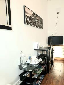 a room with a black table and a television at Gabriel Guesthouse in Rhyl