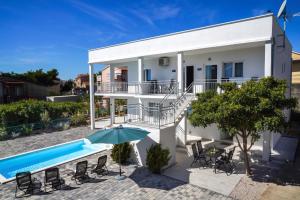 a villa with a swimming pool and a house at TayLa-Apartment Vodice in Vodice