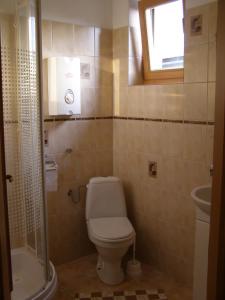 a bathroom with a toilet and a sink and a window at Privát Liptov 11 in Liptovský Mikuláš