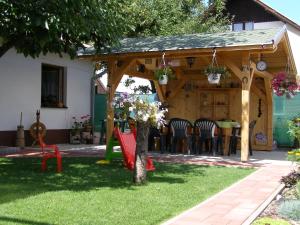 a wooden pavilion with a table and chairs in a yard at Privát Liptov 11 in Liptovský Mikuláš