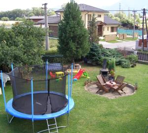 a person sitting in a chair in a backyard at Privát Liptov 11 in Liptovský Mikuláš