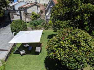 Hotel A Torre do Xudeu في توي: اطلالة علوية على حديقة بها طاولة بيضاء وكراسي