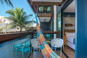 um quarto com uma rede de descanso junto a uma piscina em MEREPE SUÍTES em Porto de Galinhas