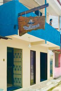 een blauw-wit gebouw met een bord erop bij Pousada Ilha do Encanto in Ilha de Boipeba
