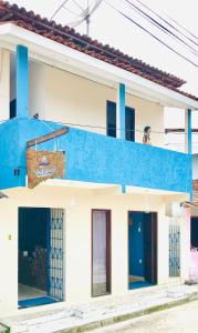 - un bâtiment bleu et blanc avec un balcon dans l'établissement Pousada Ilha do Encanto, à Île de Boipeba