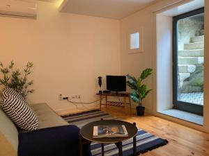 - un salon avec un canapé et une table dans l'établissement Own Places Relax Porto Studio, à Porto