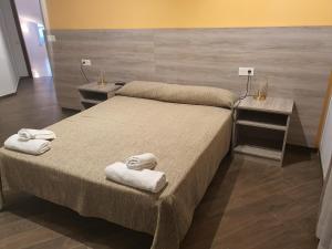sypialnia z 2 łóżkami i ręcznikami w obiekcie Pensió Costa Brava w Sant Antoni de Calonge