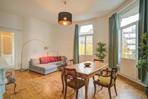アントワープにあるTheodore Residence in the Heart of Antwerpのテーブルと椅子とソファのあるリビングルーム
