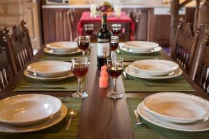 a table with plates and glasses of wine on it at Xatheri Villas in Vamos