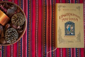 a table with a bowl of pine cones and a book at Xatheri Villas in Vamos