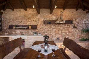 a room with a table and chairs and a stone wall at Xatheri Villas in Vamos