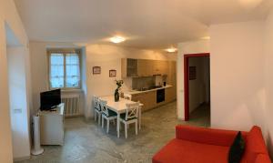 un soggiorno con divano rosso e una cucina di Chiavenna Suite a Chiavenna