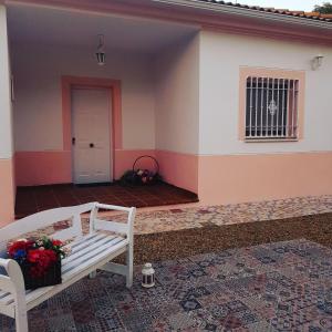 a porch of a house with a bench and a door at Casa con piscina de agua salada Villa Pepucho 1 in Córdoba