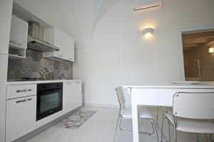 eine weiße Küche mit einem weißen Tisch und Stühlen in der Unterkunft Salentuosi - Salento Mille e una Notte in Racale